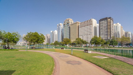 Fototapeta na wymiar Corniche boulevard beach park along the coastline in Abu Dhabi timelapse hyperlapse with skyscrapers on background.