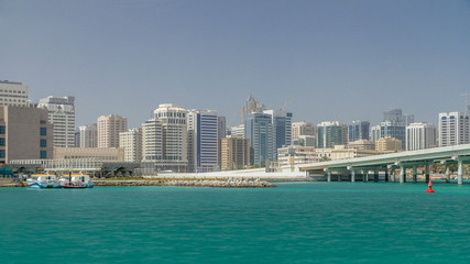 Fototapeta na wymiar Modern buildings in Abu Dhabi skyline timelapse with mall and beach.