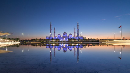 Obraz premium Sheikh Zayed Grand Mosque in Abu Dhabi day to night timelapse after sunset, UAE
