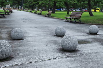 Closeup of sphere stone works on the cement pathway in public park. The beautiful natural classical background and template. 