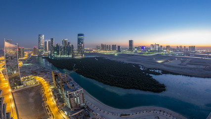 Buildings on Al Reem island in Abu Dhabi day to night timelapse from above.