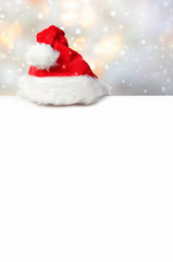 Rote Weihnachtsmütze auf weißer Aufstelltafel
