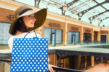 Style woman female girl in brown design hat and blue in white dots shopping bag ready for shopping in shopping mall.  Sales in shop, black Friday, tourist's shopping concept