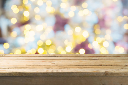 Empty wooden table over festive bokeh background