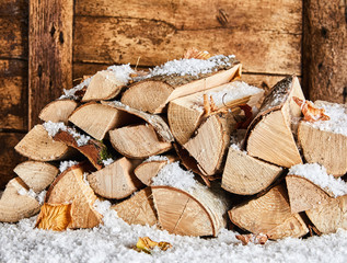 Winter woodpile outside a rustic wooden house