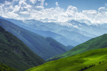 Mountains nature landscape on sunny summer day. Mountains ranges in Svaneti, Georgia. Scenery Hills and mountain. Amazing mountain range. Alpine. Green meadow covered by grass in highlands