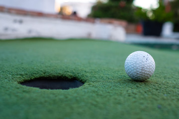 golf ball and hole in a minigolf field