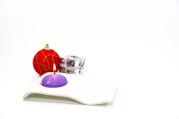 Christmas decoration, focus on the candle, red globe, shiny giftbox on white background space for text.