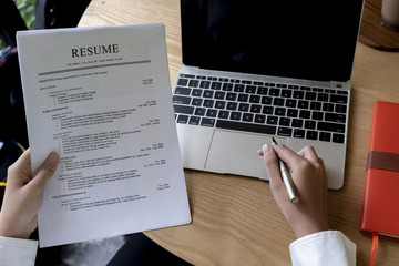 Fototapeta na wymiar Business man review his resume application on desk, laptop computer, job seeker