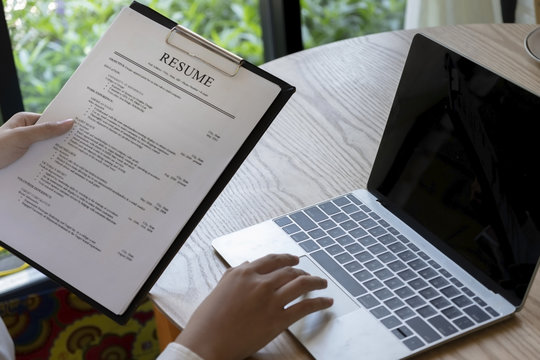 Business man review his resume application on desk, laptop computer, job seeker