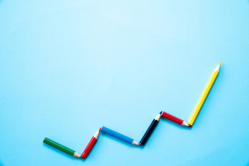 Color pencil in a pattern of a graph on white color background with copy space. Business finance...