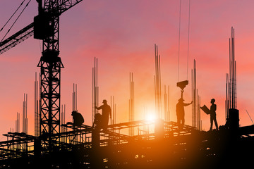 Silhouette of Engineer and worker on building site, construction site with clipping path at sunset...