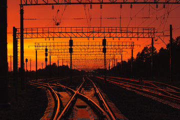 Fototapeta na wymiar Dark Silhouettes Railway Infrastructure In Dramatic Sunset Backl