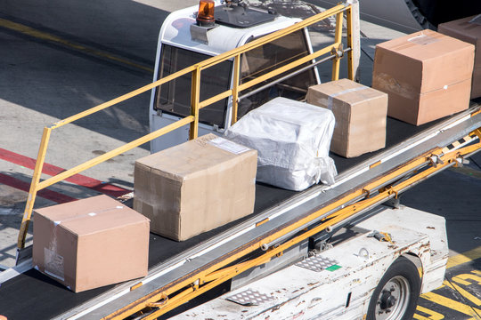 Unloading the packet from the fuselage of aircraft. The packages ride on the conveyor when loading the air plane.