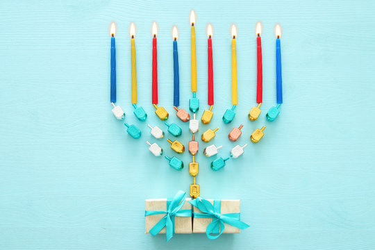 Top view image of jewish holiday Hanukkah background with traditional spinnig top, menorah (traditional candelabra) and candles.