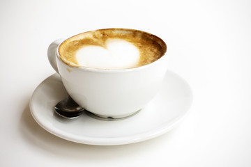 Hot latte With art milk froth in a coffee cup on a white table.