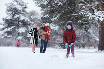 Young family with children are walking in the winter park. Winte