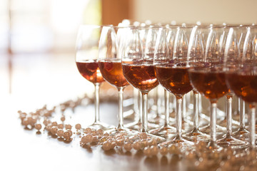 A red coloured alcohol in wine glasses.
