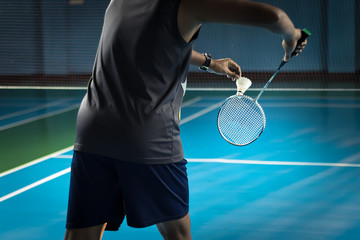 People Playing Badminton, Badminton is served on court blue background. - obrazy, fototapety, plakaty