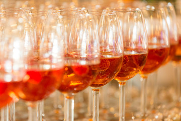 A red coloured alcohol in wine glasses.