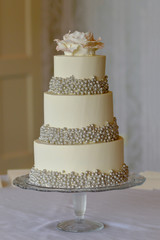 3 tier wedding cake with silver pearls and edible rose flower topper.