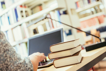 Studentin arbeitet in Bibliothek, Bücher und Laptop, Bücher im Hintergrund