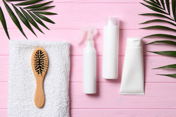 natural hair care products, hairbrush, towel and leaves on a wooden background top view. Shampoo, mask, balm. flatlay