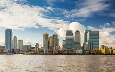 Obraz premium Modern skyscrapers of Canary Wharf with old riverfront houses and Thames in foreground, January 2018, Greenwich London