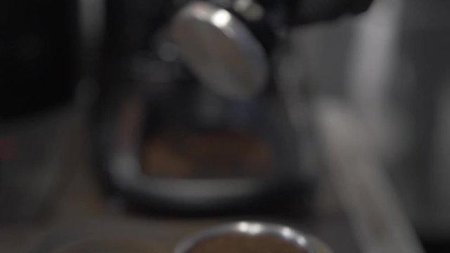 Barista pressing ground coffee for Frappe, freddo cappuccino
