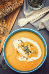 Homemade pumpkin soup served with cream and pumpkin seeds