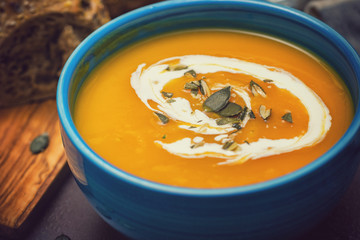 Homemade pumpkin soup served with cream and pumpkin seeds