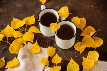 Naklejka na ściany i meble two white cups of tea in the yellow leaves, the concept of cosiness, warmth and autumnal sadness
