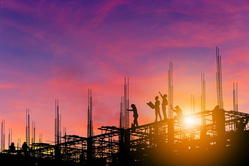 Silhouette of Engineer and worker on building site, construction site with clipping path at sunset...
