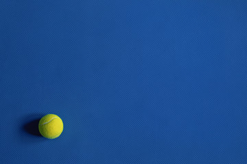 Yellow tennis ball on the blue background