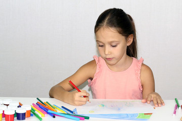 child draws with markers and paints, looking for the concept of creativity