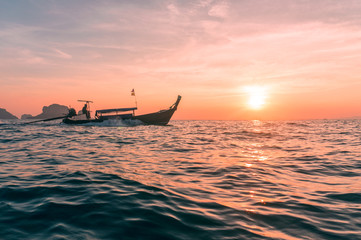 Beautiful sunset with silhouette of Longtail boat on the horizon of the sea. Thailand