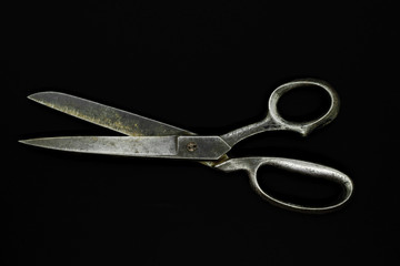 Top view of old metal scissors isolated on black background