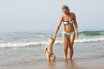 Mother and son playing on the beach in the day time