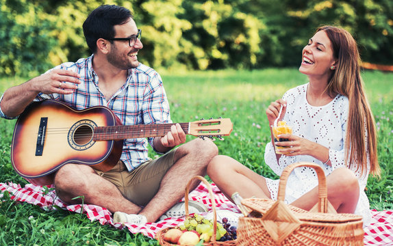 Beautiful couple enjoying picnic in the park. Love and tenderness, dating, romance, lifestyle concept