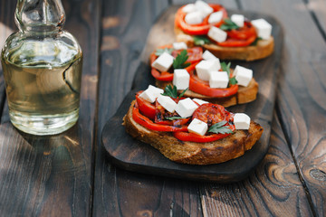 Homemade crostini with grilled tomatoes, bell pepper and feta cheese, natural tasty countryside snack for healthy living, close up