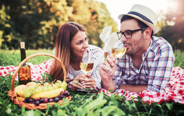 Loving couple enjoying picnic in the park. Love and tenderness, dating, romance, lifestyle concept