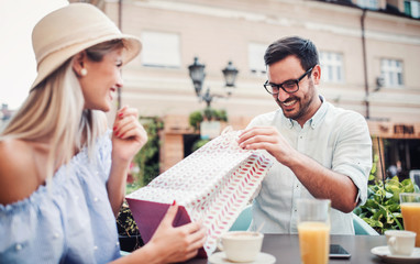 Shopping time. Young couple resting in the cafe after shopping. Consumerism, lifestyle concept