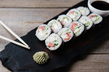 Japanese food art, sushi restaurant, traditional cuisine. Delicious sushi rolls served on wooden tray with wasabi and chopsticks
