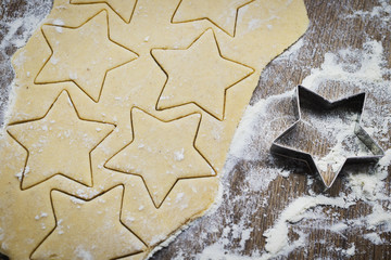 Christmas baking. Making gingerbread biscuits. Cookie dough and cookie cutters on kitchen counter,...