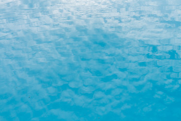 Beautiful blue water background with reflection of cloud on sky.