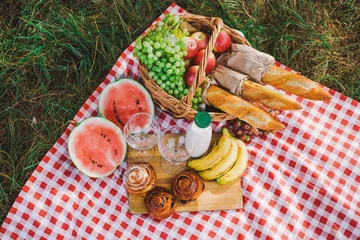 Wall murals Picnic Healthy food for picnic outside. View from above of fresh buns, bread, yogurt, bananas, watermelon, green grape and red apples. Horizontal color image.