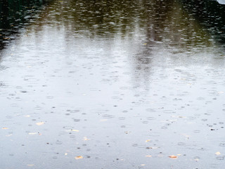raindrops fall on wet surface of asphalt road