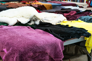 many colored sheep skins on table