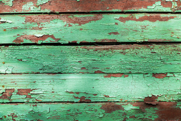 Fototapeta na wymiar Texture background of wooden planks covered with old peeling paint of green color