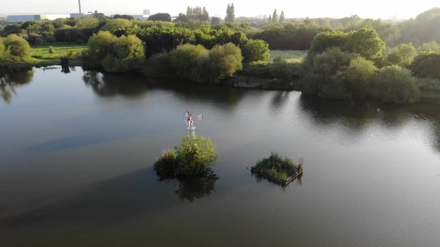 Flying over the wind turbine in the middle of the Bardag Lake in the Eastbrookend Country Park towards Tom Thumb Lake.
